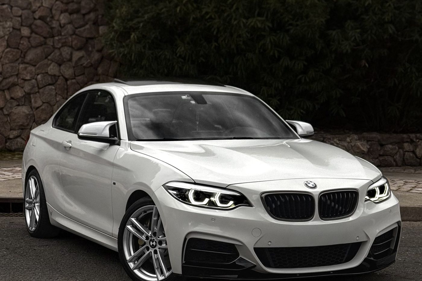 Vista frontal del BMW M240i con los faros encendidos
